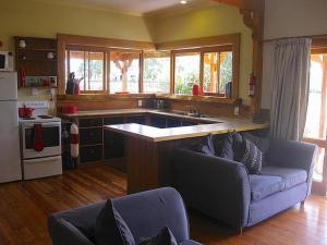 a kitchen with a couch and a sink in a room at The Ski House on Miharo - Rangataua Holiday Home in Ohakune