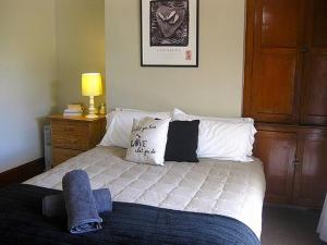 a bedroom with a bed with white sheets and pillows at The Ski House on Miharo - Rangataua Holiday Home in Ohakune