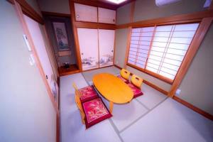 a small room with a wooden table and a table andwindows at Shiki no Sai in Mongawa