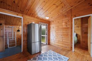 cocina con nevera en una habitación con paredes de madera en Lakefront Lodge - Kuratau Holiday Home en Kuratau