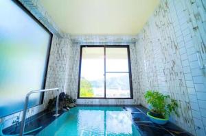 a bathroom with a swimming pool with a window at Shiki no Sai in Mongawa