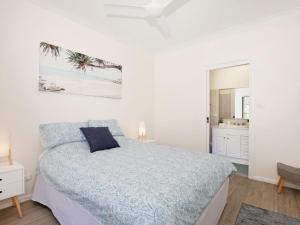 Habitación blanca con cama y baño. en Bayview I Absolute Waterfront with Jetty I 5 Mins to Hyams Beach, en Erowal Bay