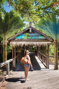 a woman in a bikini standing on a bridge with a surfboard at Airlie Beach Magnums - Adults Only in Airlie Beach