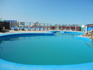 una grande piscina con acqua blu e sedie di Hotel Central park a Santa Clara del Mar