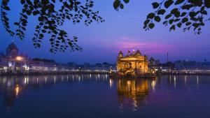 a building sitting in the middle of a body of water at Madpackers Amritsar in Amritsar