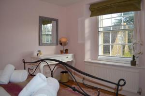 um quarto branco com uma cama e uma janela em Darly Cottage em Bourton on the Water