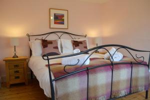 um quarto com uma cama com uma estrutura de metal em Darly Cottage em Bourton on the Water