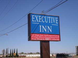 a sign for an appliance inn on a street at Executive Inn Mojave in Mojave