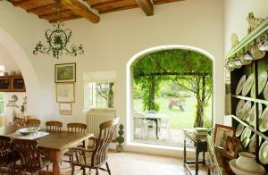 uma sala de jantar com uma mesa e uma grande janela em Centolivi 8 em Montecastello