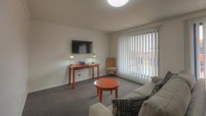a living room with a couch and a table at INVERELL RSM CLUB MOTEL in Inverell