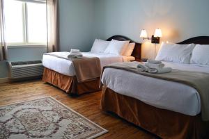 a hotel room with two beds and a window at Anchor Inn Hotel and Suites in Twillingate