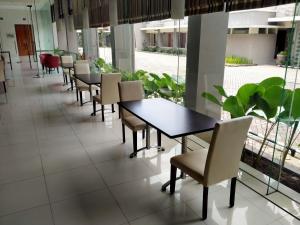 una fila di tavoli e sedie in una caffetteria di Hotel Quirin a Semarang