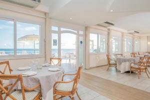 a dining room with tables and chairs and the ocean at Hotel Cavalluccio Marino in Santa Marinella