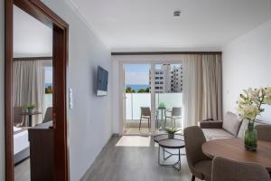 a living room with a couch and a table at Kapetanios Limassol Hotel in Limassol