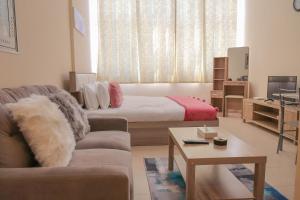 a living room with a bed and a couch at SHH - Furnished Studio Apartment, Silicon Gates 4 in Dubai