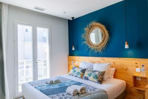 a bedroom with blue walls and a bed with towels on it at Hôtel Café Miramar in Le Grau-du-Roi