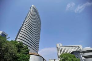 a tall building in front of two tall buildings at Kobe Portopia Hotel in Kobe