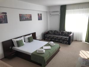 a hotel room with a bed and a couch at Cristiana Studio Eforie Nord in Eforie Nord