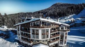 Un gran edificio con nieve encima. en Spider House Aparthotel, en Pamporovo