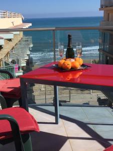 a red table with two glasses and a bottle of wine at Apartamentos Marjal 3 in Guardamar del Segura