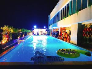 ein großer Pool vor einem Gebäude in der Nacht in der Unterkunft Holiday One Can Tho Hotel in Cần Thơ