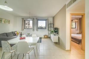 a living room and dining room with a white table and chairs at Stay Jaffa Jerusalem in Jerusalem
