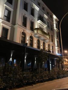 a white building with a black awning in front of it at Boscovich Boutique Hotel in Podgorica