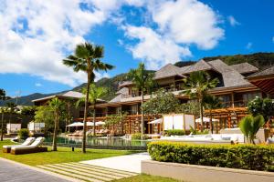 un complexe avec une piscine et des palmiers dans l'établissement L'Escale Resort Marina & Spa - Small Luxury Hotels of the World, à Mahé