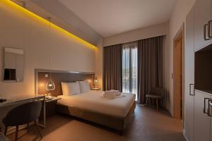 una camera d'albergo con un grande letto e una scrivania di Avra Nafpliou a Nauplia