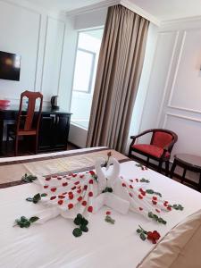 una habitación de hotel con una cama con rosas. en Khanh Linh Hotel, en Da Nang