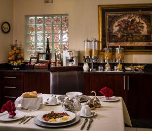 a table with plates of food on top of it at Gallo Manor Executive Bed & Breakfast in Johannesburg