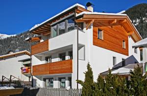 uma casa nas montanhas com varandas de madeira em Ferienwohnung Haus Reider em Sarentino