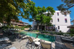 a swimming pool with chairs and a building at Avra Nafpliou in Nafplio