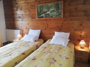 two beds in a room with wooden walls at Adret in Saint-Martin-de-Belleville