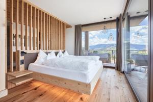 a bedroom with a large bed and a large window at Hotel Fischer in Bressanone