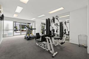 a gym with several tread machines in a room at Burwood Serviced Apartments in Burwood