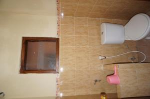 baño con ducha con espejo y ventana en QQ Guesthouse, en Kalasan