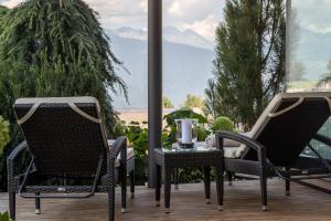 2 Stühle und ein Tisch auf einer Terrasse mit Aussicht in der Unterkunft Hotel Fischer in Brixen