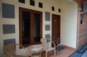 un balcón de una casa con 2 sillas y una puerta en QQ Guesthouse, en Kalasan