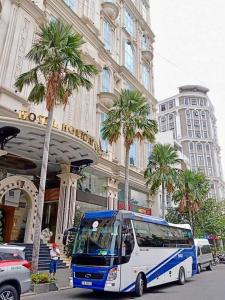 un autobus blu e bianco parcheggiato di fronte a un hotel di Holiday One Can Tho Hotel a Can Tho