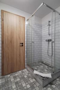 y baño con ducha y puerta de cristal. en Tó-Part Panzió Kőszeg, en Kőszeg