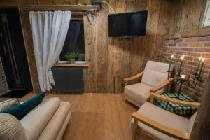 a living room with a couch and a chair and a television at Willa Anna in Szklarska Poręba