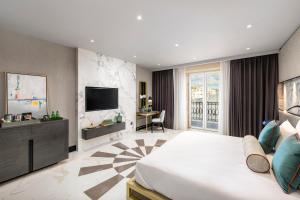 a hotel room with a bed and a television at Lure Hotel & Spa - Adults Only in Mellieħa