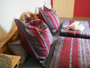 einen Haufen Kissen auf einem Bett mit einem Buch in der Unterkunft Ferienwohnung an der Waldmühle in Reulbach