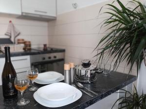 eine Küchentheke mit zwei Tellern und Gläsern Wein in der Unterkunft Beki Apartment in Bar