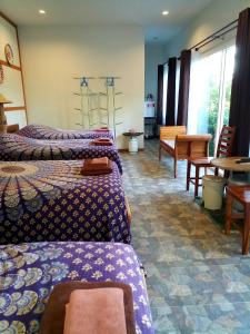 homestay568 Branch 2 في Muang Suang: غرفة فندقية بسريرين وطاولة وكراسي