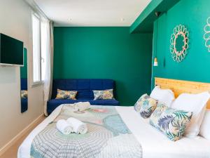 a bedroom with a large bed with green walls at Hôtel Café Miramar in Le Grau-du-Roi