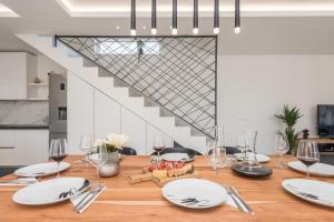 a dining room table with white plates and wine glasses at Villa Pollux - Adriatic Luxury Villas in Vrsi