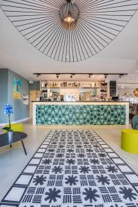 a lobby with a restaurant with a large ceiling at Hôtel Café Miramar in Le Grau-du-Roi