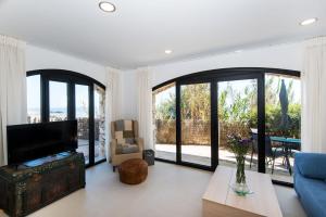 a living room with a couch and a tv and windows at Beach Pearl Cala de Mijas in Mijas